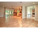 Open-concept living area with wood floors, sliding glass doors, and kitchen view at 1610 Se 22Nd Ave, Ocala, FL 34471