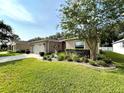 A single-story home with well-kept lawn, decorative accents, and mature landscaping at 16405 Sw 14Th Avenue Rd, Ocala, FL 34473