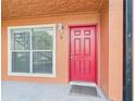 Inviting front entrance with bright red door, window, and clean facade creating a welcoming first impression at 1801 Caralee Blvd # 2, Orlando, FL 32822
