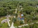 Aerial view of the home nestled in a lush, green neighborhood, showcasing its serene and private setting at 19370 Saint Benedict Dr, Dunnellon, FL 34432