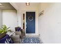 Cozy front porch with seating, a decorative wreath on the door, and a welcoming rug at 19942 Sw 96Th Pl, Dunnellon, FL 34432