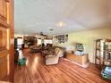 Spacious living room with wood floors, plush sofas, and many pictures on the walls at 20100 Sw 95 St, Dunnellon, FL 34431