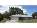 Charming single-story home featuring an attached two-car garage and landscaped front yard at 27 Cedar Tree Ter, Ocala, FL 34472