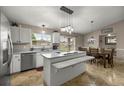 Bright eat-in kitchen featuring white cabinets, stainless steel appliances, granite countertops, and modern pendant lighting at 380 Ne 53Rd St, Ocala, FL 34479