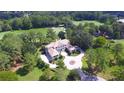 Stunning aerial view of property surrounded by lush greenery, landscaping, and golf course at 4026 Nw 85Th Ter, Ocala, FL 34482