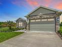 Single-Gathering home displaying stone facade, well-manicured lawn, and a spacious two-car garage at 4370 County Road 121D, Wildwood, FL 34785