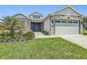 Beautiful single-story home with stone accents, manicured lawn, and a two-car garage at 4370 County Road 121D, Wildwood, FL 34785