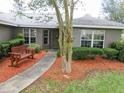 Inviting front entrance with a charming bench, manicured shrubs and a mulch bed enhance the curb appeal at 5083 Se 26Th St, Ocala, FL 34480