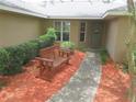 Close up of a inviting front entrance with a charming bench and well manicured shrubbery at 5083 Se 26Th St, Ocala, FL 34480