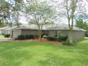The exterior of this single story home features lush landscaping with a quaint bench and inviting walkway at 5083 Se 26Th St, Ocala, FL 34480