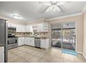 Bright kitchen with white cabinets, stainless steel appliances, and sliding doors to the pool area at 5720 Se 20Th St, Ocala, FL 34480