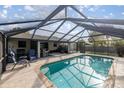 Relaxing screened-in pool with lounge chairs and outdoor grill, perfect for entertaining at 5720 Se 20Th St, Ocala, FL 34480