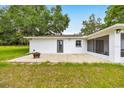 Covered patio area offering a relaxing space, complemented by a spacious backyard and well-kept lawn at 6350 Nw 135Th Ave, Morriston, FL 32668