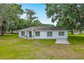Well-kept one-story home with a pristine white exterior, inviting front yard, and manicured lawn at 6350 Nw 135Th Ave, Morriston, FL 32668