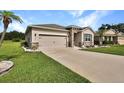 Exterior view of a home, showcasing a two-car garage, stone accents, and a well-kept lawn at 6405 Sw 88Th Loop, Ocala, FL 34476