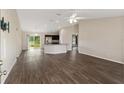 Spacious open-concept living room with hardwood floors, modern ceiling fan and access to kitchen at 6561 Sw 129Th Loop, Ocala, FL 34473