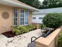 Outdoor patio area with comfortable seating, decorative wall art, and well-maintained landscaping for relaxation at 7251 Sw 115Th Pl, Ocala, FL 34476