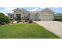 Charming single Gathering home with a lush lawn, beautiful landscaping, decorative stone and a blue front door at 8772 Se 130Th Loop, Summerfield, FL 34491