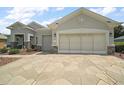 Attached two car garage with decorative stone trim and large decorative driveway pavers at 8772 Se 130Th Loop, Summerfield, FL 34491