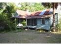 Single-story home with a screened front porch and mature palm trees at 1050 E Highway 329, Citra, FL 32113