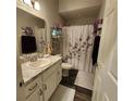 Bathroom featuring floral shower curtain and marble countertop for a fresh, clean aesthetic at 11412 Sw 51St Cir, Ocala, FL 34476