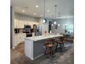 Well-lit kitchen boasts white cabinets, stainless steel appliances, and a stylish breakfast bar with pendant lighting at 11412 Sw 51St Cir, Ocala, FL 34476