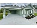 View of the front exterior with covered parking and well-manicured landscaping at 13319 Sw 106Th Pl, Dunnellon, FL 34432