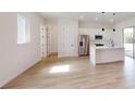 A stylish, modern kitchen with an island, stainless steel appliances, and light wood-look flooring at 15215 Sw 43Rd Ct, Ocala, FL 34473