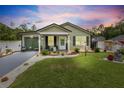 Charming home with manicured lawn, featuring a covered front porch, modern siding, and inviting curb appeal at 15324 Sw 40Th Place Rd, Ocala, FL 34481