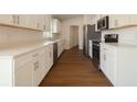 Modern kitchen with stainless steel appliances, white cabinets, and light countertops at 3529 Sw 150Th Ct, Dunnellon, FL 34432
