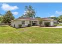 Landscaped home with a well-maintained lawn, mature trees, and an attached two-car garage at 4085 Ne 17Th Ave, Ocala, FL 34479