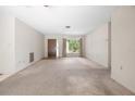 Empty living room showing carpet, front door, and a window with natural lighting at 4467 Sw Channel Heights Ct, Dunnellon, FL 34431