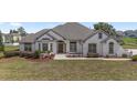 Charming white stucco home with dark trim, a well-maintained lawn, and a cozy, inviting curb appeal at 5092 Ne 81St Blvd, Wildwood, FL 34785