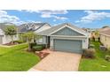 Charming single-story home with a brick driveway, well-manicured landscaping, and a two-car garage at 5651 Nw 40Th Pl, Ocala, FL 34482