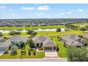 Aerial shot of a landscaped home with a lake view in a neighborhood with well-maintained lawns and landscaping at 6683 Sw 97Th Terrace Rd, Ocala, FL 34481