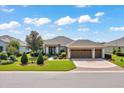 Charming single-story home with a three-car garage and manicured front yard featuring lush landscaping at 6683 Sw 97Th Terrace Rd, Ocala, FL 34481