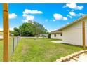 Fenced backyard with green grass and a small patio, ideal for outdoor activities at 6989 Se 52Nd Pl, Ocala, FL 34472