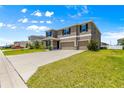 Two-story home boasting a three-car garage, beautiful landscaping, and a spacious driveway at 8142 Sw 59Th Ave, Ocala, FL 34476