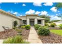 Inviting single-story home with manicured landscaping and a walkway leading to a double-door entrance at 8961 Se 130Th Loop, Summerfield, FL 34491