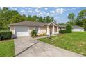 Single-story home with a concrete driveway and lush green lawn at 9 Bahia Trace Loop, Ocala, FL 34472