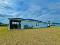 Exterior view of home, highlighting the spacious backyard and covered lanai with comfortable seating at 9253 Sw 58Th Cir, Ocala, FL 34476
