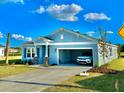 Beautiful single-story home showcasing a two-car garage, manicured lawn, and light blue siding at 9253 Sw 58Th Cir, Ocala, FL 34476