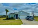 Inviting single-Gathering home featuring a two-car garage, well-maintained lawn, and blue trim at 9253 Sw 58Th Cir, Ocala, FL 34476