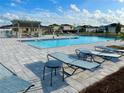 Relaxing community pool area featuring lounge chairs and a shaded pergola at 9253 Sw 58Th Cir, Ocala, FL 34476