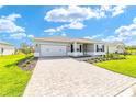 Beautiful single-story home boasting a brick driveway, manicured lawn, and attached two-car garage at 9865 Sw 105Th Ct, Ocala, FL 34481