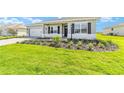 A nicely landscaped front yard with fresh mulch, green grass, and a charming single-story home at 9865 Sw 105Th Ct, Ocala, FL 34481