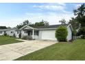 Single-story home features an attached one car garage and a well-manicured front lawn at 11248 Sw 76Th Ter, Ocala, FL 34476
