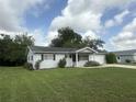 Single-story home features a well-kept lawn, a manicured landscape, and attached garage at 11248 Sw 76Th Ter, Ocala, FL 34476