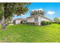 Well-maintained home exterior with lush green lawn, mature landscaping, and manicured shrubbery at 13715 Se 88Th Ct, Summerfield, FL 34491