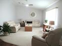 Bright living room with neutral walls, plush seating, a ceiling fan, and natural light for a comfortable space at 14192 Sw 112Th Cir, Dunnellon, FL 34432